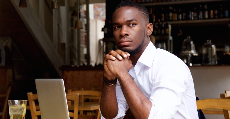 Jovem empreendedor negro, em seu restaurante delivery, pensando sobre o Pixel do Facebook rastreando seus clientes